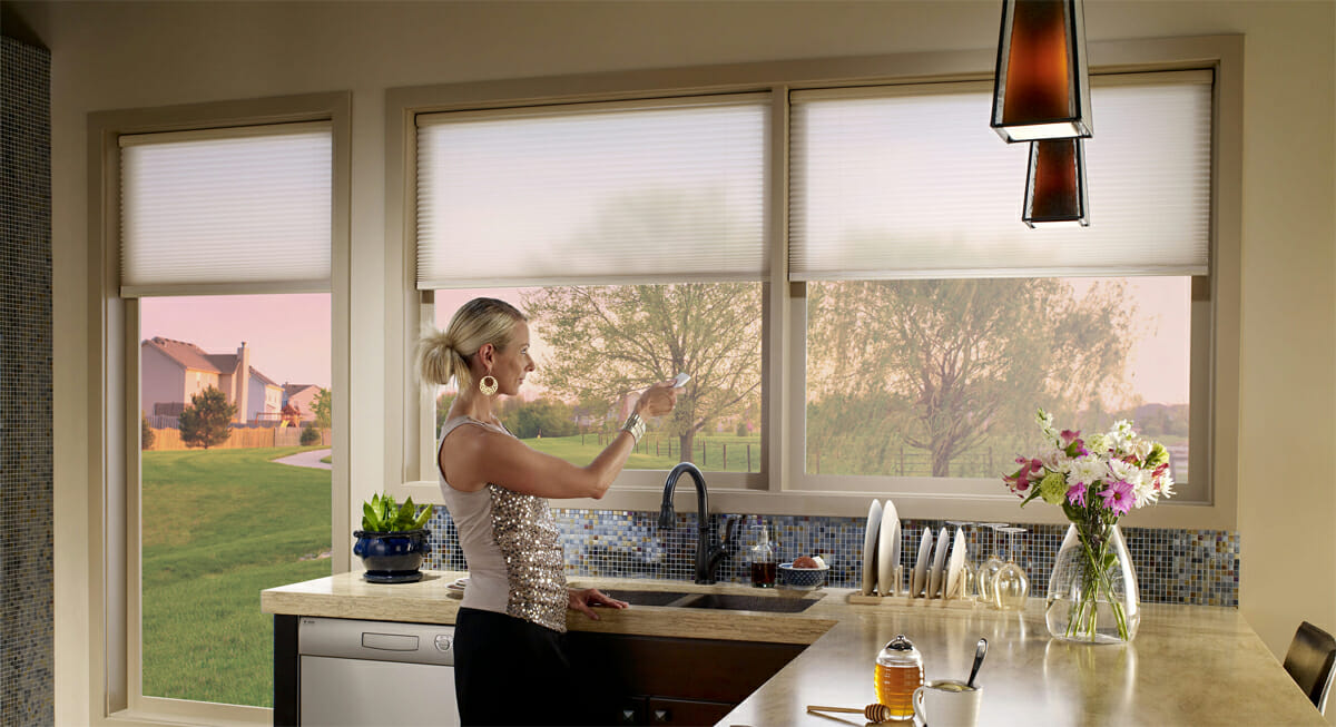 Woman raising blinds with a remote control